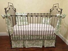 a baby crib with green and white bedding