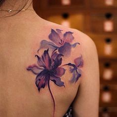 the back of a woman's shoulder with flowers painted on it