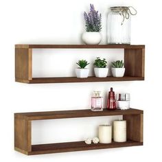 two wooden shelves with plants and candles on them