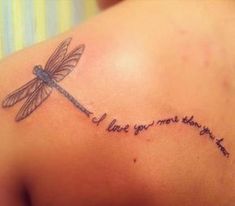 a dragonfly tattoo on the back of a woman's shoulder with words written below it