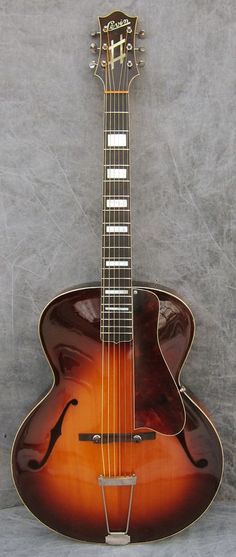 an old guitar sitting against a wall