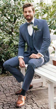 a man in a blue suit sitting on a white bench