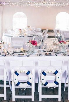 the tables are set with white and blue linens for an elegant wedding reception in a tent