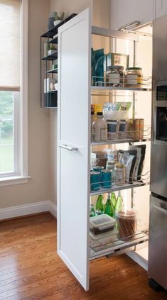 an open refrigerator freezer sitting inside of a kitchen