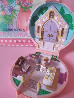 a pink dollhouse with a little kitchen and dining area in the inside of it