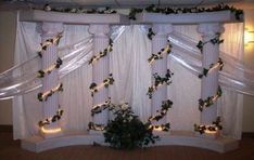 a room decorated with white curtains and string lights