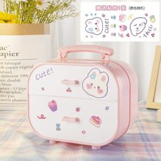 a pink and white suitcase sitting on top of a table next to a vase with flowers