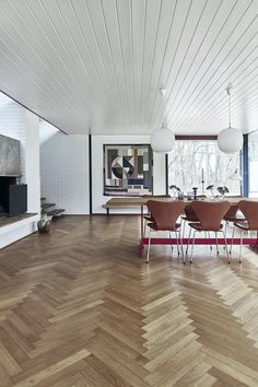 a dining room with wooden floors and white walls, along with an open fire place