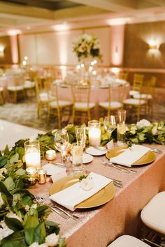 the tables are set with gold plates and candles for an elegant wedding reception or special event