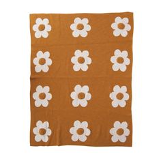 an orange and white flowered blanket on a white background, with small white flowers in the center