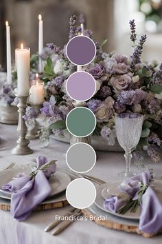 a table topped with plates covered in purple and white flowers next to tall candle holders