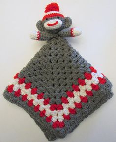 a crocheted sock with a red and white monkey on it's back