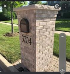 a brick mailbox sitting on the side of a road