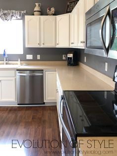 a kitchen with white cabinets and black appliances