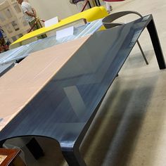 a blue bench sitting in the middle of a room next to other tables and chairs