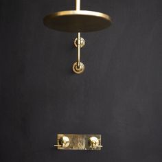 a black wall with a gold light fixture