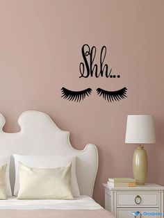 a bedroom with a bed, nightstand and wall decal that says shh on it