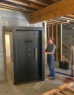 a man standing in front of a black locker inside of a building under construction with tools