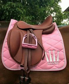 a brown and pink horse saddle with trees in the background