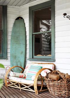 a surfboard sitting on top of a porch next to a chair