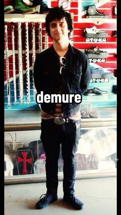 a man standing in front of a store window with the words demure on it