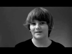 black and white photo of a young boy with short hair wearing a t - shirt