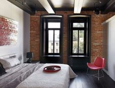 a bed sitting in a bedroom next to a window and a red plate on top of it