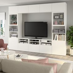 a living room filled with furniture and a flat screen tv on top of a white entertainment center