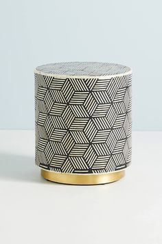 a small black and white box with gold trimmings on the top, sitting on a table