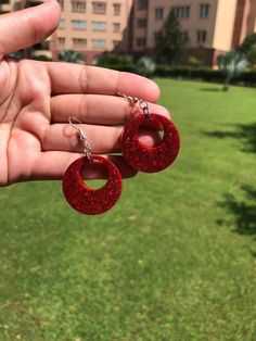 Add a pop of color to your outfit with these bold red glitter resin hoop earrings. Handcrafted with care, each pair shines with a unique sparkle, perfect for those who love statement jewelry. These lightweight earrings are comfortable for all-day wear and make an eye-catching addition to any accessory collection. Looking for something custom? We offer personalized options to match your style. Contact us for custom colors or designs to make these hoops uniquely yours! All of my jewelry is handcra Trendy Red Circular Jewelry, Plastic Round Jewelry For Parties, Red Plastic Party Jewelry, Round Plastic Party Jewelry, Trendy Red Resin Earrings, Red Glitter Earrings For Party, Trendy Red Plastic Jewelry, Red Glitter Party Earrings, Red Glitter Jewelry For Party