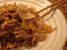 a white plate topped with food and chopsticks