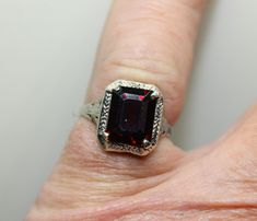 A great piece for any day wear. This is a bright bold red Pyrope (type red natural) garnet set in a filagree setting. The garnet is an emerald cut and measures 10 x 8mm and weighs approximately 2 carats. The setting is a vintage Art Deco pierced filagree style. The stone is set in 4  prongs. The band is currently a size 7 US and can be sized inhouse if needed. The band is stamped and test 14k god and wighs2.1 grams. The band is in great shape with minimal wear. Antique Red Gemstone Signet Ring, Luxury Vintage Garnet Rings, Vintage Garnet Rings With Polished Finish, Garnet Gem, Garnet And Gold, Red Band, Etsy Gold Ring, 2 Carat, Vintage Art Deco