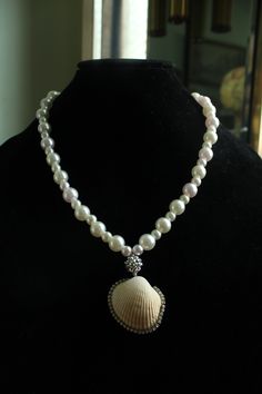 Embrace the summer sun in true style with the Mystic Tides Pendant Necklace! This beauty comes in a pristine white color that instantly lends your look luxury and an ethereal vibe, featuring alternate big and small faux pearls that are complemented with a sphere charm to truly form a look of whimsy and wonder. Rhinestone embellished seashell is sure to brighten up your sunny days. Pair with strapless dresses! Screw Barrel Clasp Closure Material: Faux Pearl Beads, Real Seashell, Elastic String