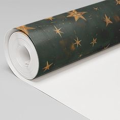 a roll of wrapping paper with gold stars on it