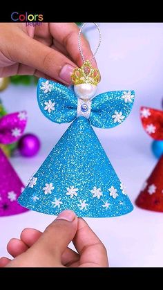 someone is decorating a christmas tree ornament with blue glitter and white snowflakes