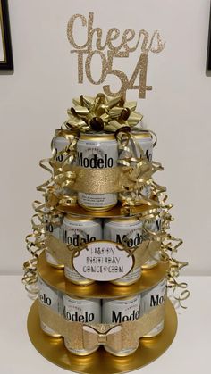 a cake made out of cans with gold ribbon and bow on top that says modelo