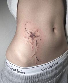 a woman's stomach with a flower tattoo on it