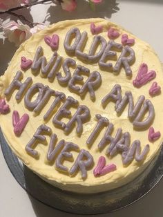 a cake that is decorated with letters and hearts on it, sitting on a table