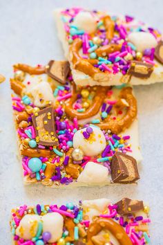 several pieces of food with sprinkles and candy on them sitting on a table