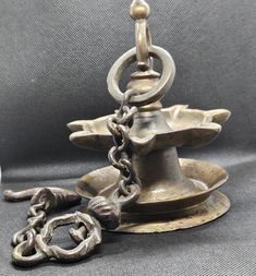 an old metal candle holder with chains hanging from it