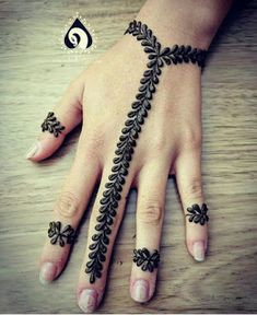 a woman's hand with henna tattoos on it