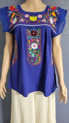 This Beautiful Hand embroidered blouse has a unique Mexican inspired Floral design and flirty lace sleeves. The blouse is a fresh cotton linen embroidered with cotton string. Fitted Blue Tops With Intricate Embroidery, Blue Fitted Tops With Intricate Embroidery, Casual Multicolor Tops With Embroidered Sleeves, Cotton Blouse With Multicolor Embroidered Sleeves, Cotton Blouse With Multicolor Embroidery And Embroidered Sleeves, Casual Purple Blouse With Floral Embroidery, Summer Blouse With Machine Embroidery, Fitted Blouse With Embroidered Neckline And Short Sleeves, Casual Embroidered Short Sleeve Top