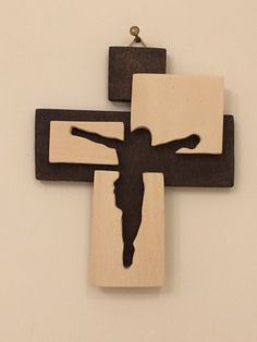 a wooden cross with a black silhouette of jesus hanging from it's center piece