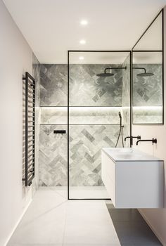 a modern bathroom with marble tile and black accents