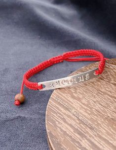 "Handmade red Buddhist woven thread bracelet. The S925 silver charm is inscribed with the Buddhist six true words mantra: Om Mani Padme Hum. These Six True Words 'Om Mani Padme Hum' - are the most common mantra in Tibet. This mantra produces the sound and vibration which allows you to feel at one with the universe. The mantra is considered to have high spiritual and creative power. Six True Words Meaning: Om means the vibration of the universe, symbolizes one's impure body, speech, and mind. Ma Spiritual Sterling Silver Braided Bracelet Gift, Personalized Spiritual Red Bracelets, Handmade Silver Braided Bracelet Gift, Red Personalized Spiritual Bracelets, Personalized Red Spiritual Bracelets, Handmade Adjustable Red Sterling Silver Bracelet, Silver Braided Bracelet As Gift, Handmade Sterling Silver Braided Friendship Bracelets, Traditional Sterling Silver Braided Bracelet As Gift