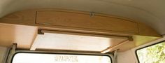 the inside of an rv with wood paneling on the ceiling and window trims