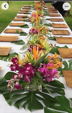 a long table with flowers and plates on it