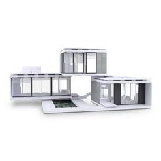 three white model houses sitting on top of a table next to each other with windows and doors