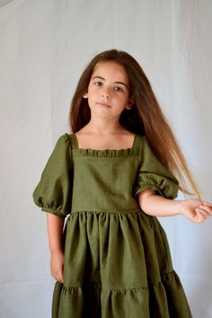 Fabulous flounced linen dress with puff sleeve, straight bodice, front and back ruffles. Back closure with coconut wooden buttons. This dress has two very fluffy flounces, which create a large wheel making the dress very scenographic. Puff sleeves can be made either with elastic or with a band. Ask for it before ordering. The color in the photo is olive green but you can choose it in other colors. Linen is medium weight, also perfect for fall. ♥SIZE GUIDE: 12 months, 32 Inch height 2 years, 35 I Birthday Outfit Green, Boho Flower Girl Dress, Green Flower Dress, Rustic Flower Girl Dress, Boho Flower Girl, Minimal Dress, 1st Birthday Outfit, White Flower Girl Dresses, Olive Green Dresses