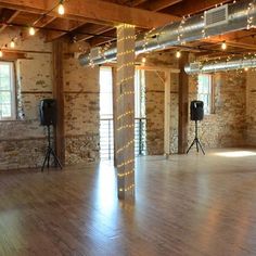 an empty room with wooden floors and lights